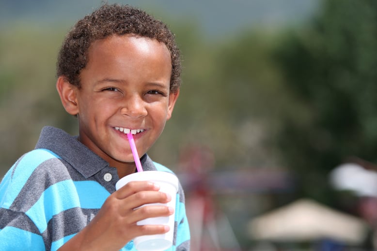 Young boy drinking and smiling